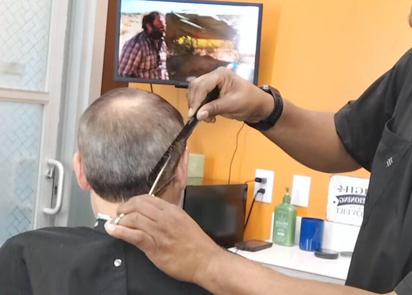 Barber crafting haircut at The Introvert Men's Grooming Lounge, Chandler, Arizona, US.