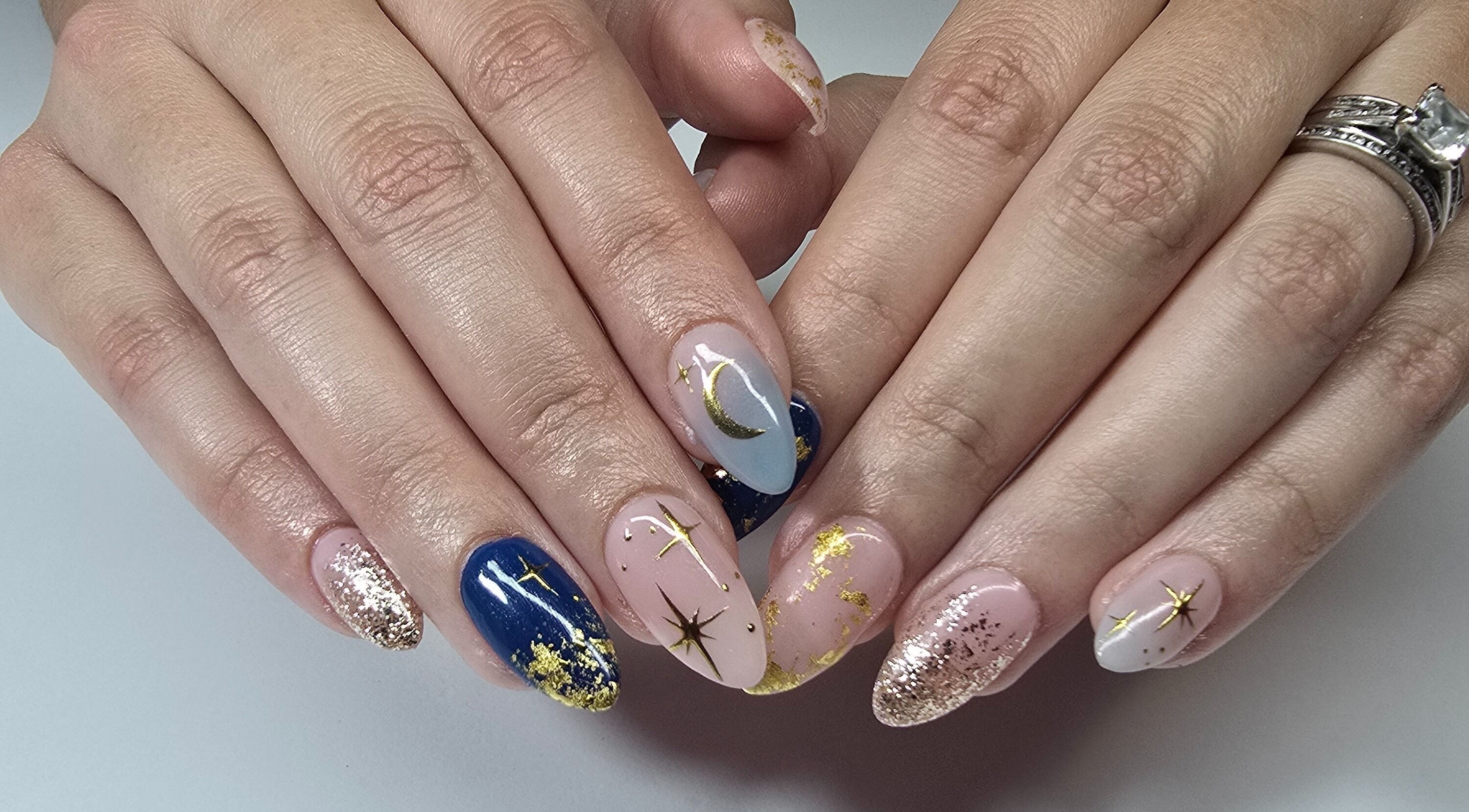 Stunning celestial nail art at Nash & Co Nails, Narangba, Queensland, AU. Blue and gold designs sparkle vividly.