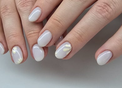 Stylish nail art at Nash & Co Nails in Narangba, Queensland, AU showcasing delicate white polish and floral designs.