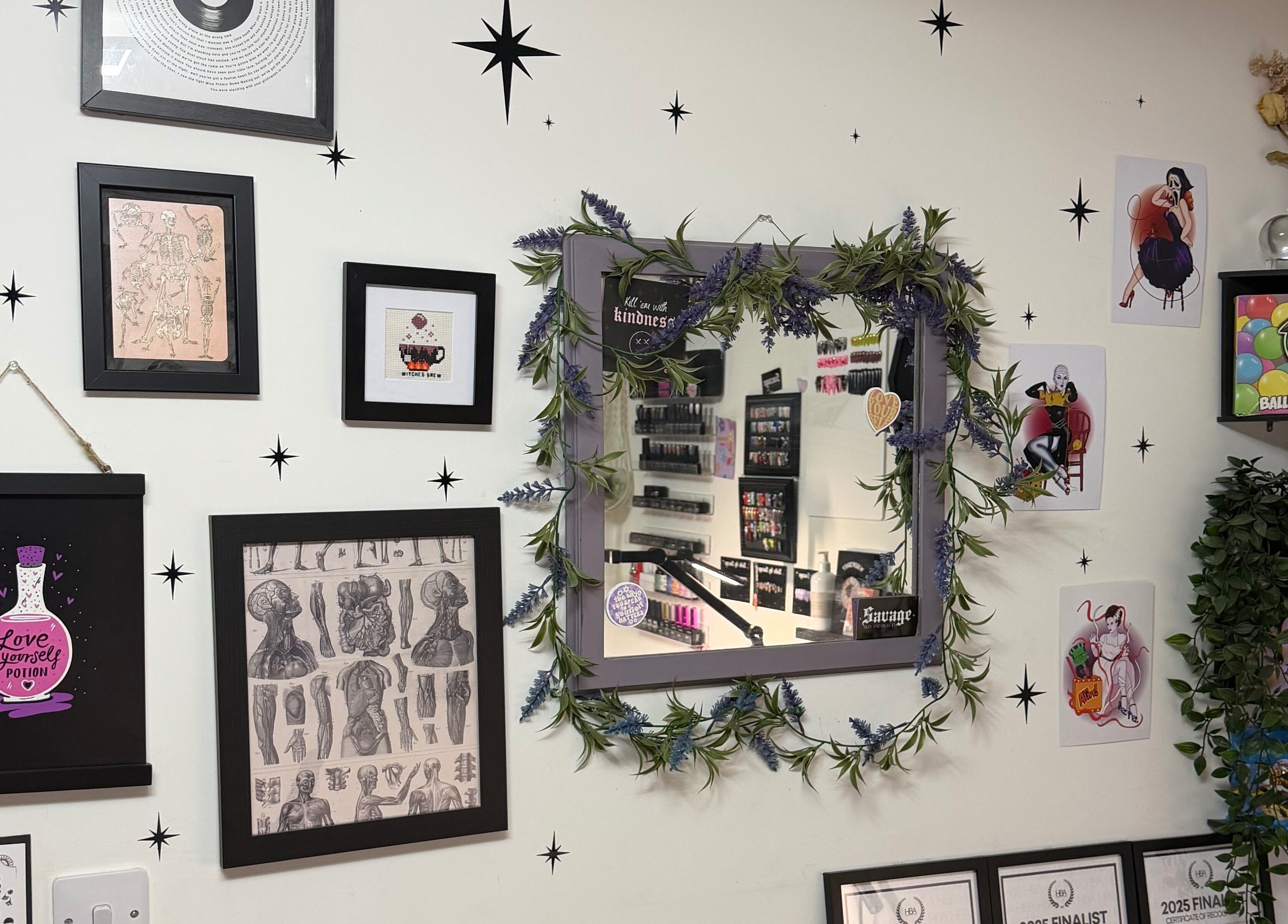 Decorative wall at Savage Skin and Beauty, Stockton-on-Tees, England showcasing eclectic art and a lavender mirror.