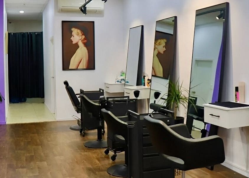 Modern salon interior at Glam Plus Hair & Beauty Salon, Auckland, NZ, featuring stylish chairs and wall art.