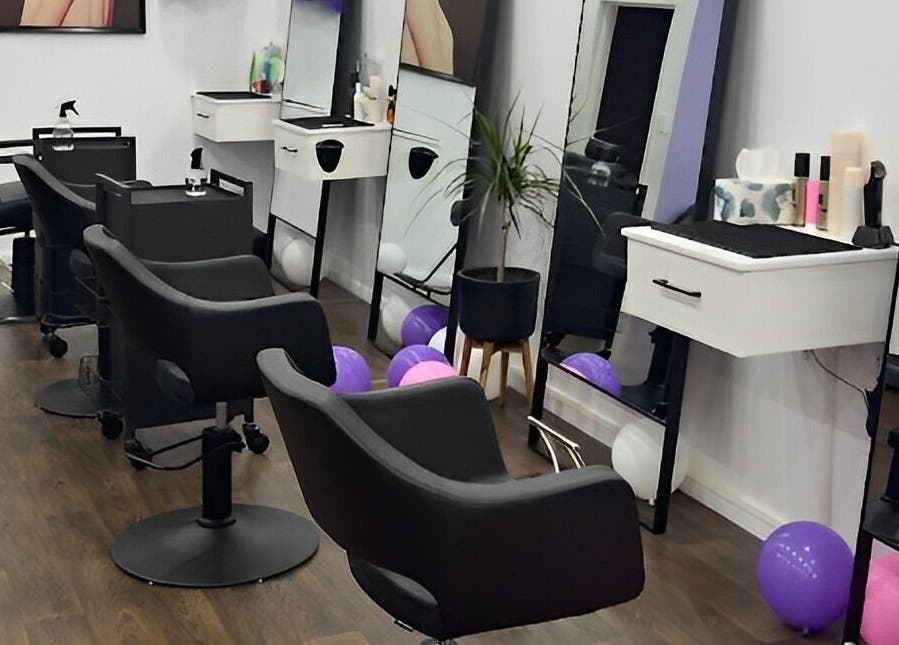 Stylish salon interior at Glam Plus Hair & Beauty Salon, Auckland, NZ, featuring sleek black chairs and mirrors.