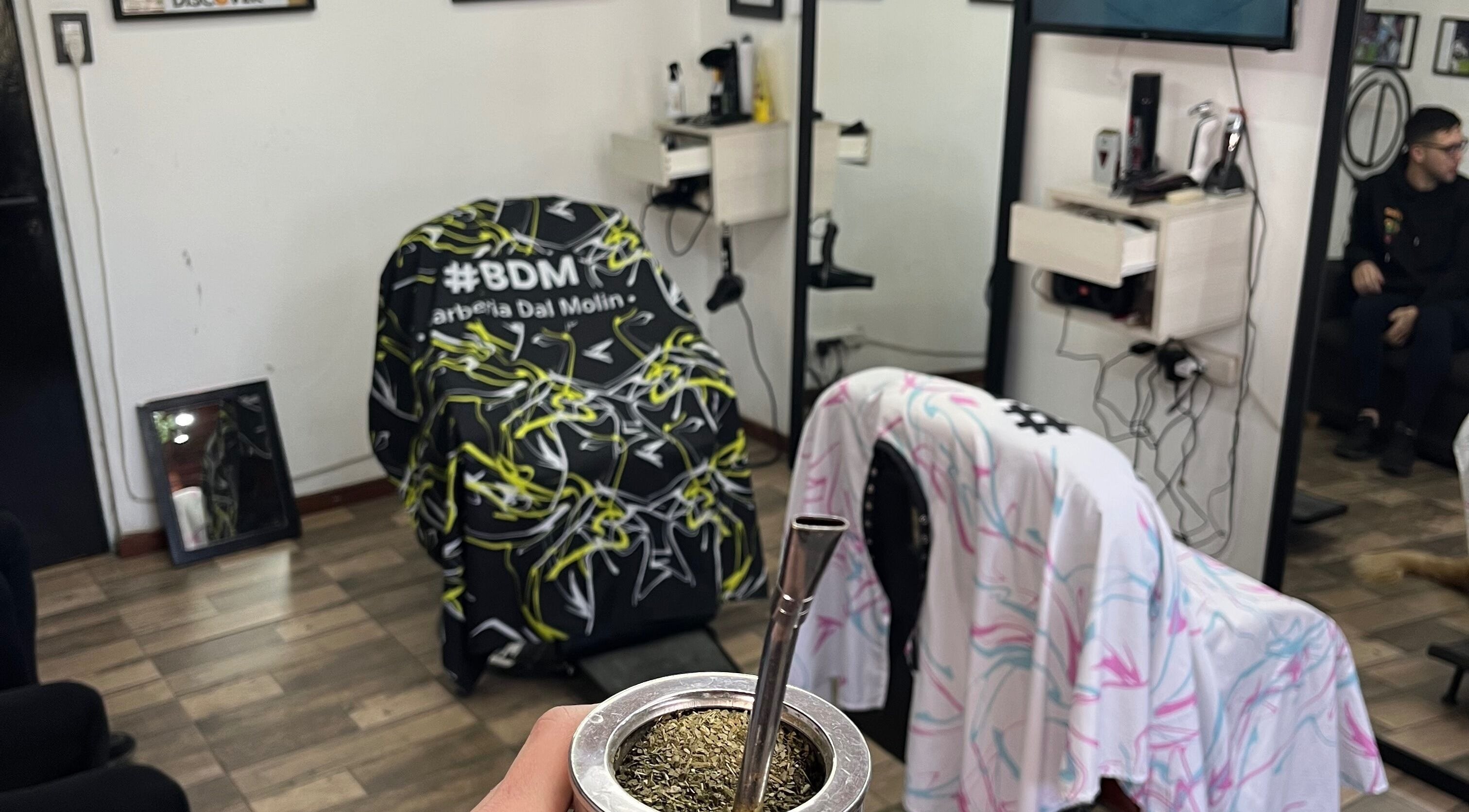 Interior de BDM Barbería Dal Molin en Awj, Santa Fe, AR con sillas cubiertas y una infusión de mate.