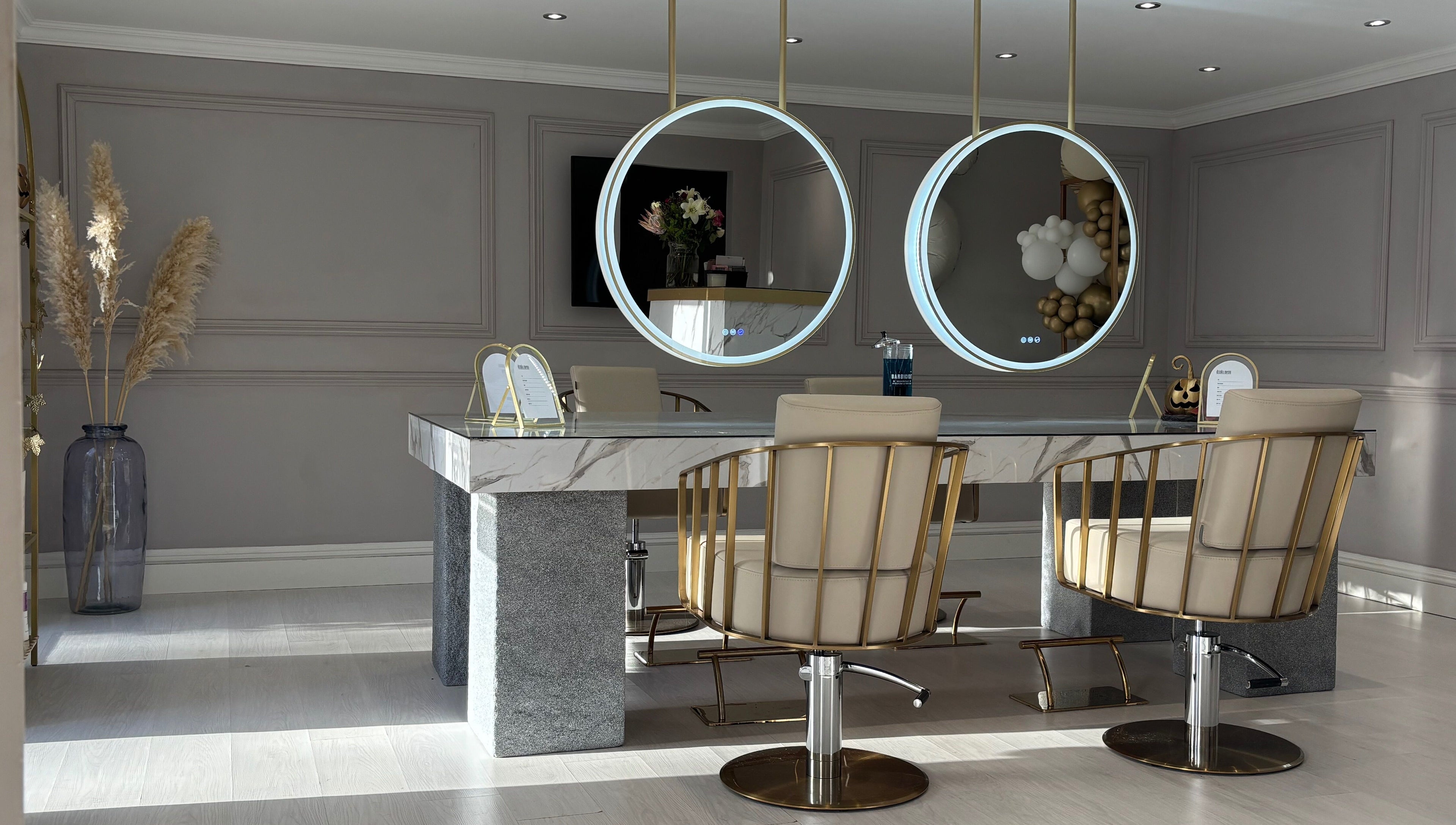 Chic salon interior at Secret Salon, Pucklechurch, England with modern chairs and circular mirrors.