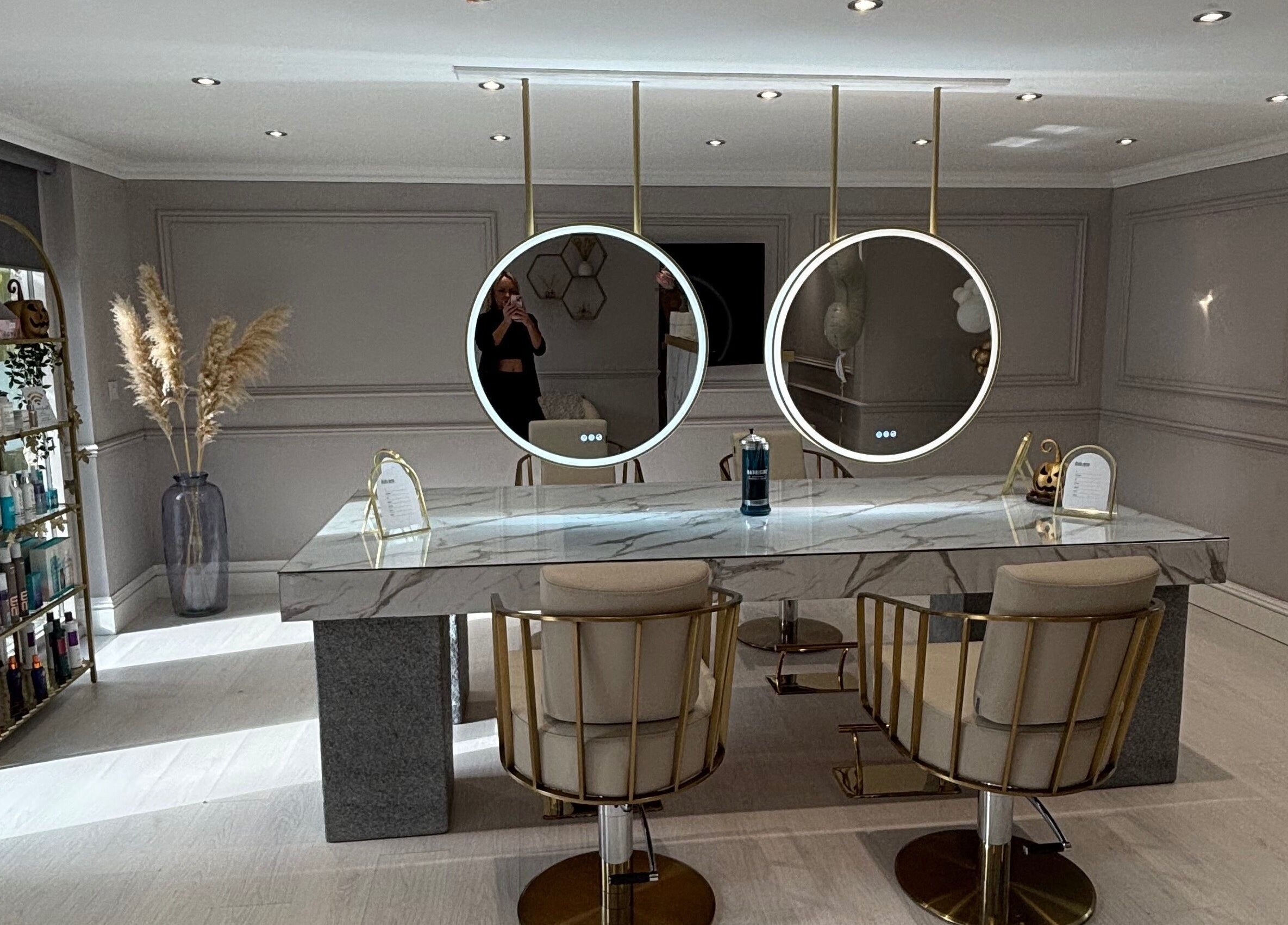 Chic marble vanity with circular mirrors at Secret Salon, Pucklechurch, England, GB. Modern design and elegance.