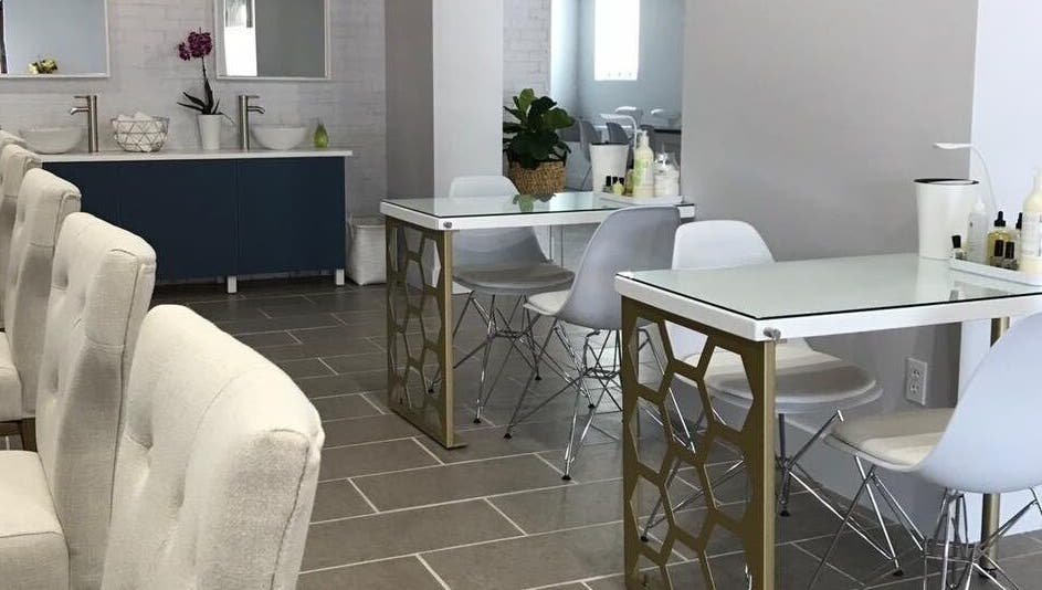 Chic interior of Top Coat Nail Studio in Bryn Mawr, Pennsylvania, US featuring modern nail tables and comfy chairs.