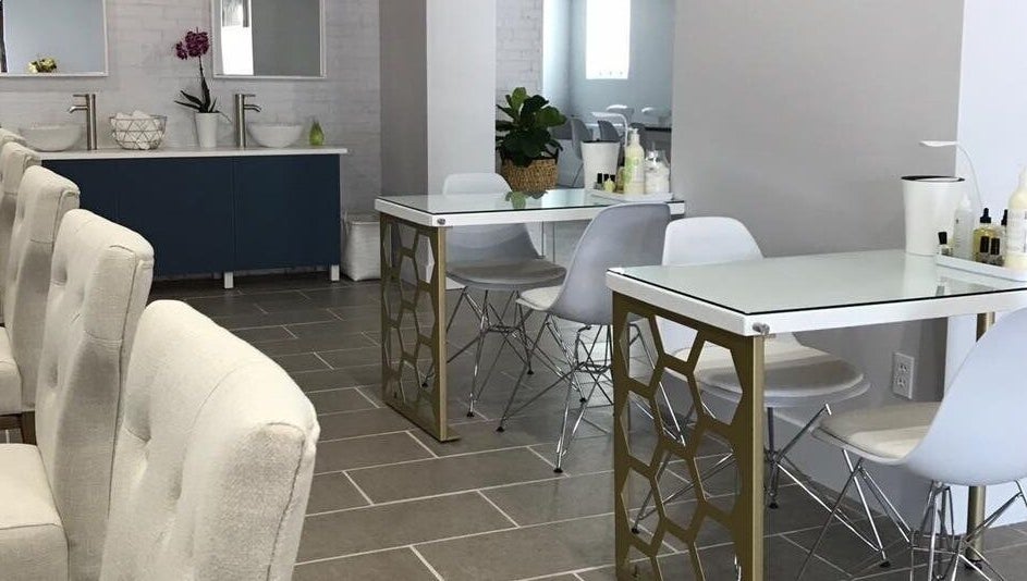 Chic interior of Top Coat Nail Studio in Bryn Mawr, Pennsylvania, US featuring modern nail tables and comfy chairs.