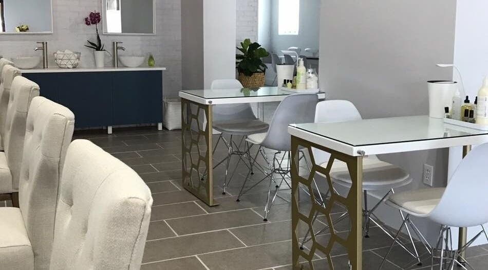 Chic interior of Top Coat Nail Studio in Bryn Mawr, Pennsylvania, US featuring modern nail tables and comfy chairs.