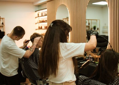 Stylists at work in Marta Beauty Salon and Academy, London, England, GB, creating chic hairstyles.