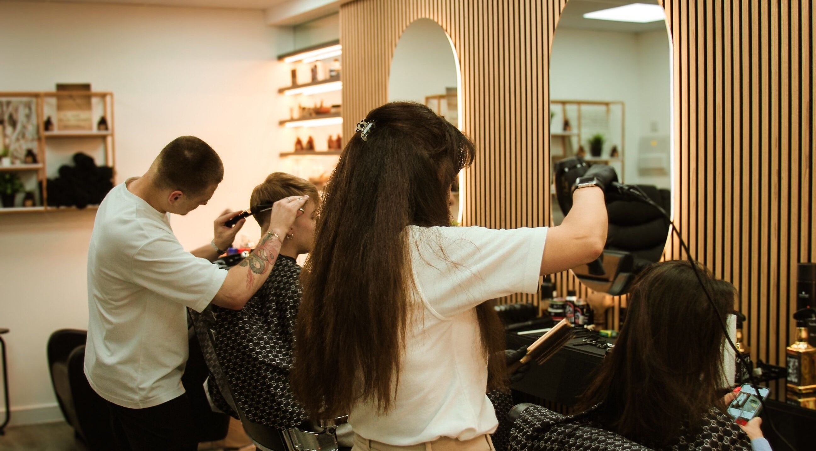 Stylists at work in Marta Beauty Salon and Academy, London, England, GB, creating chic hairstyles.