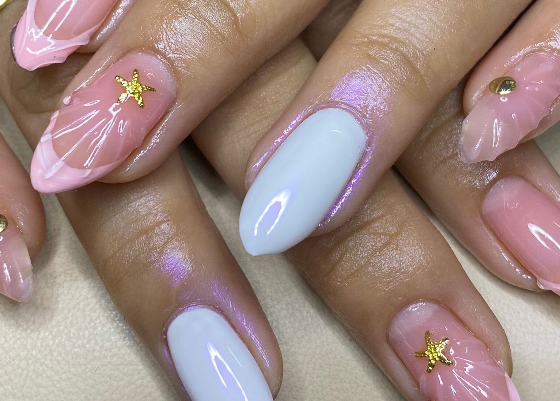Elegant nail art featuring pink and white designs with star accents at The Glamorium, Cultuurtuin, Paramaribo, SR.