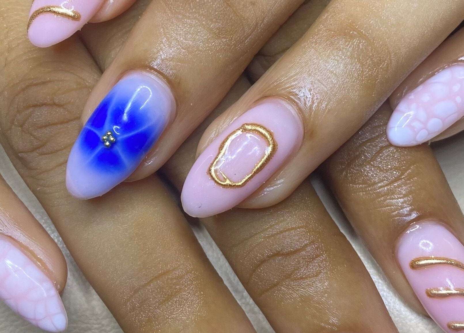 Intricate nail art with blue, gold accents at The Glamorium, Cultuurtuin, Paramaribo, SR.