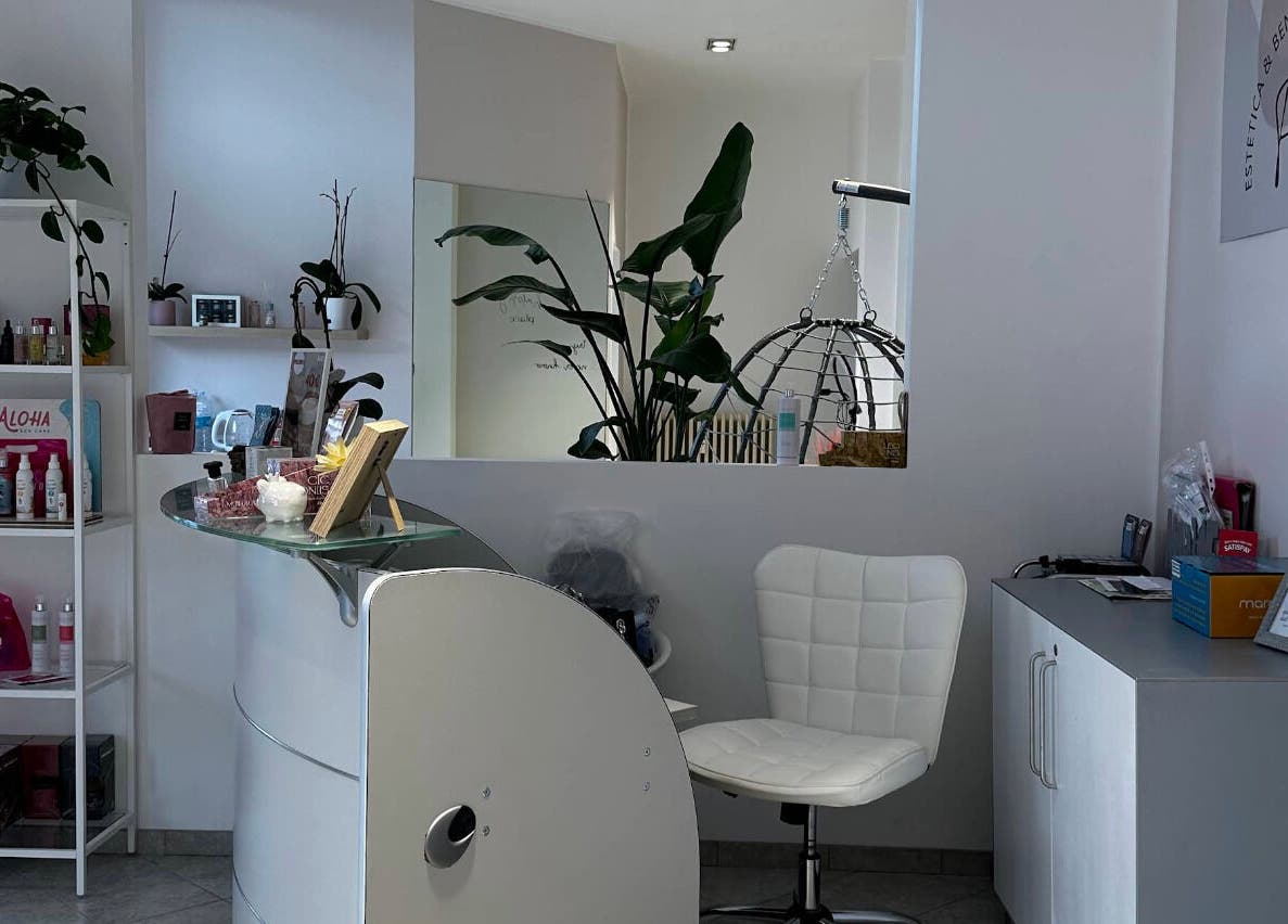 Reception elegante di Per Te - Estetica & Benessere a Villasanta, Lombardia, IT con sedia bianca e piante.