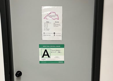 Entrance door of True North Esthetics, Terrace Bay, Ontario, CA, displaying operation hours and safety grade.