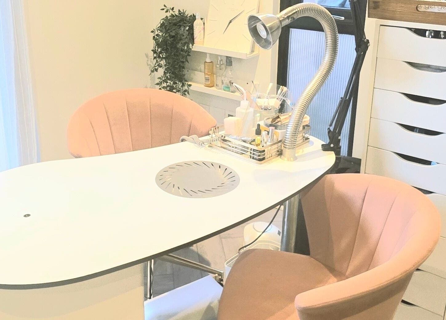 Stylish nail station at Nicola's Nails and Beauty in Whitchurch, England, GB with plush chairs and modern decor.