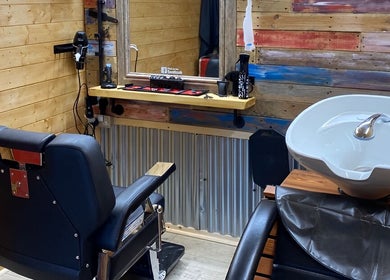 Cozy interior of The Barber Shack at Saint Martin's, England, GB with wooden walls and modern amenities.