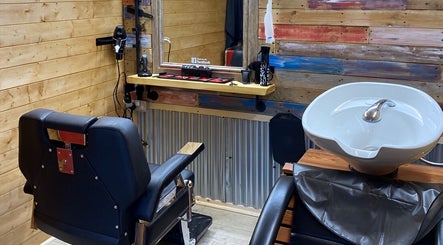 Cozy interior of The Barber Shack at Saint Martin's, England, GB with wooden walls and modern amenities.