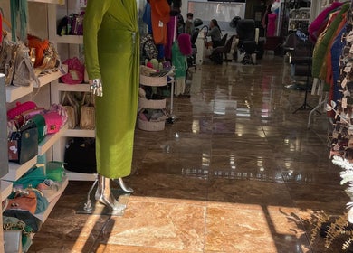Elegant fashion display at Glammy Beauty, London, England, GB with handbags and chic green dress.