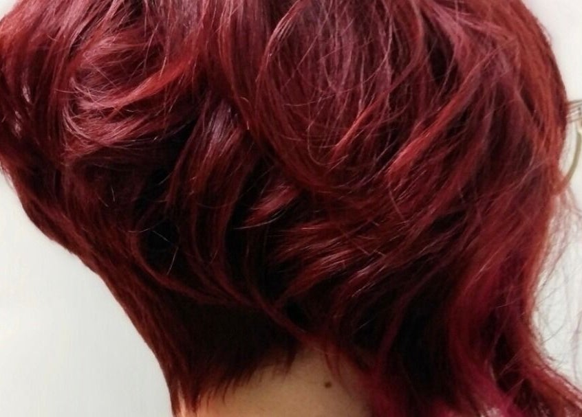 Vibrant red hairstyle from Jonny Styles in Austin, Texas, US showcases rich color and expert styling.