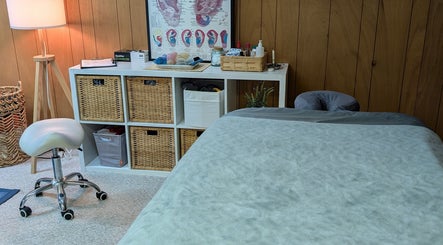 Cozy therapy room at Alyssa Acupuncture & TCM in Edmonton, Alberta, CA with massage table and wooden decor.