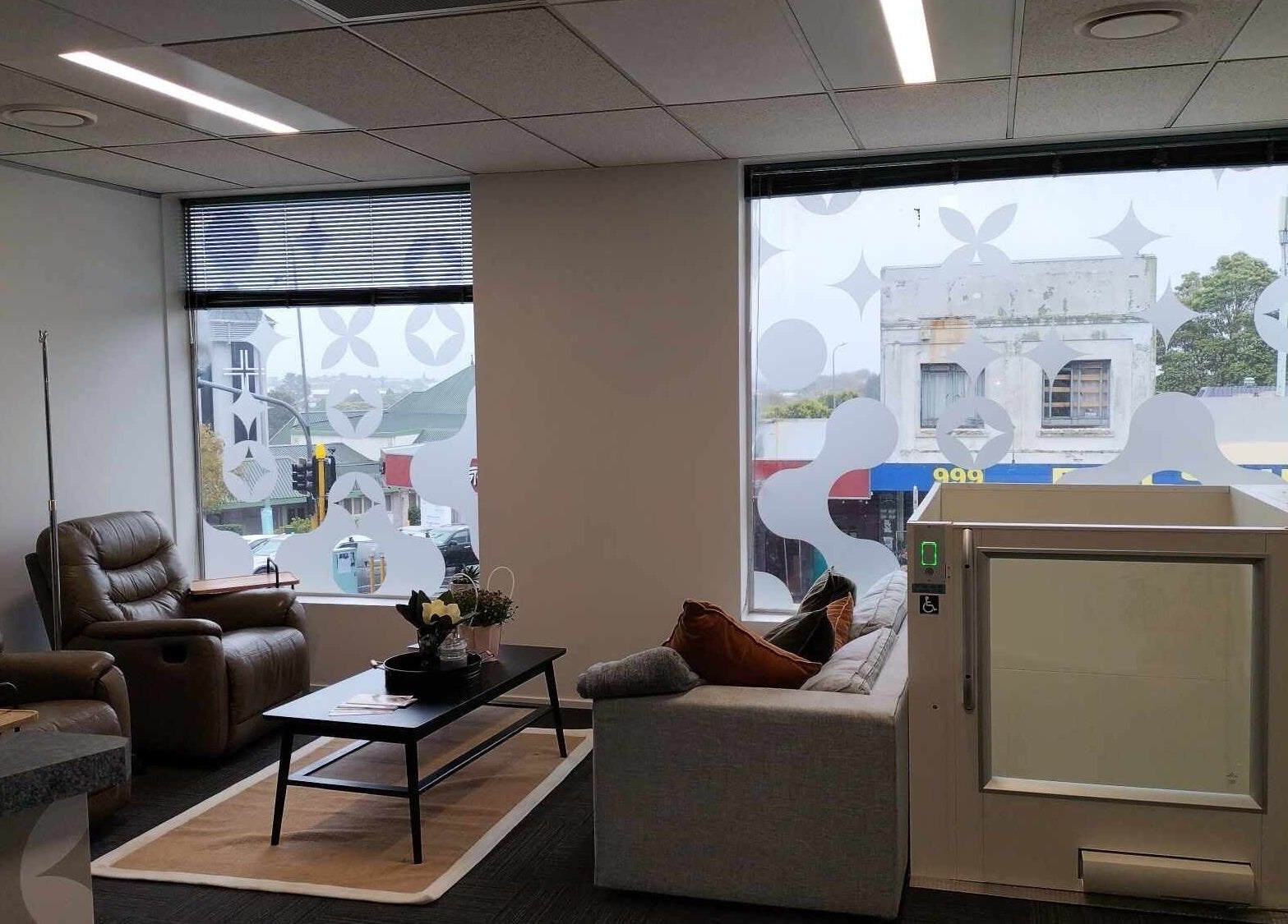 Relaxing lounge with leather chairs at Viva Clinics, Auckland, NZ, featuring a stylish window view.