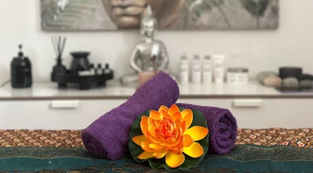 Relaxing therapy setup at Thai Massage Greenock, Greenock, Scotland, GB, with purple towels and lotus flower.