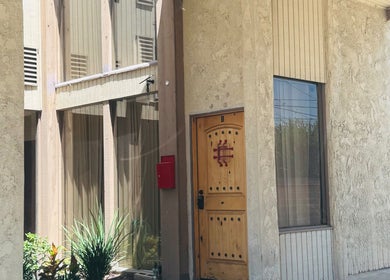 Elegant entry at Kendra, Downey, California, US showing rustic wood door and modern facade.