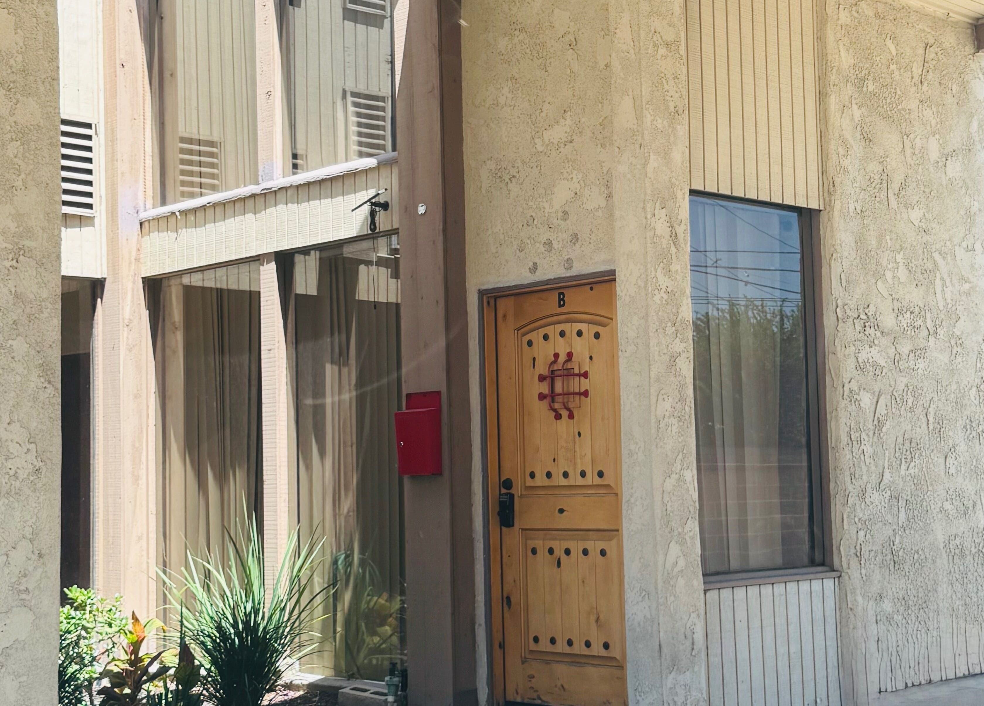 Charming entrance of Pulchrify by Kendra in Downey, California, US, featuring a wooden door and glass windows.