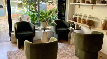 Cozy seating area at Magic Turtle Clinic, Avalon Beach, New South Wales, AU with plants and herbal jars.