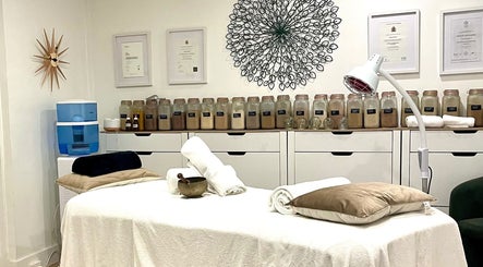 Massage room at Magic Turtle Clinic, Avalon Beach, New South Wales, AU with jars of herbs and plush towels.
