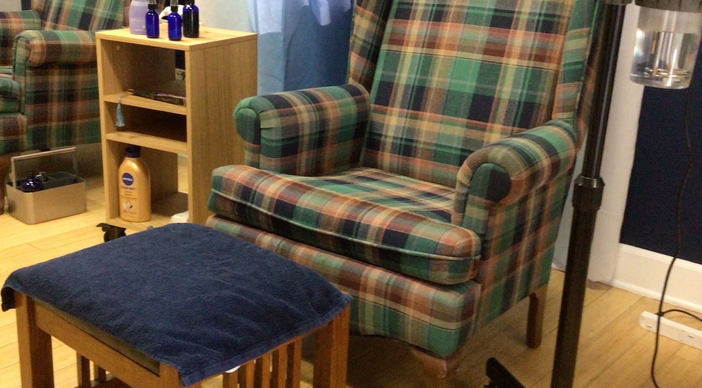 Cozy plaid chair and footrest at Ca Nail Bliss, Downey, California, US, inviting for relaxation.
