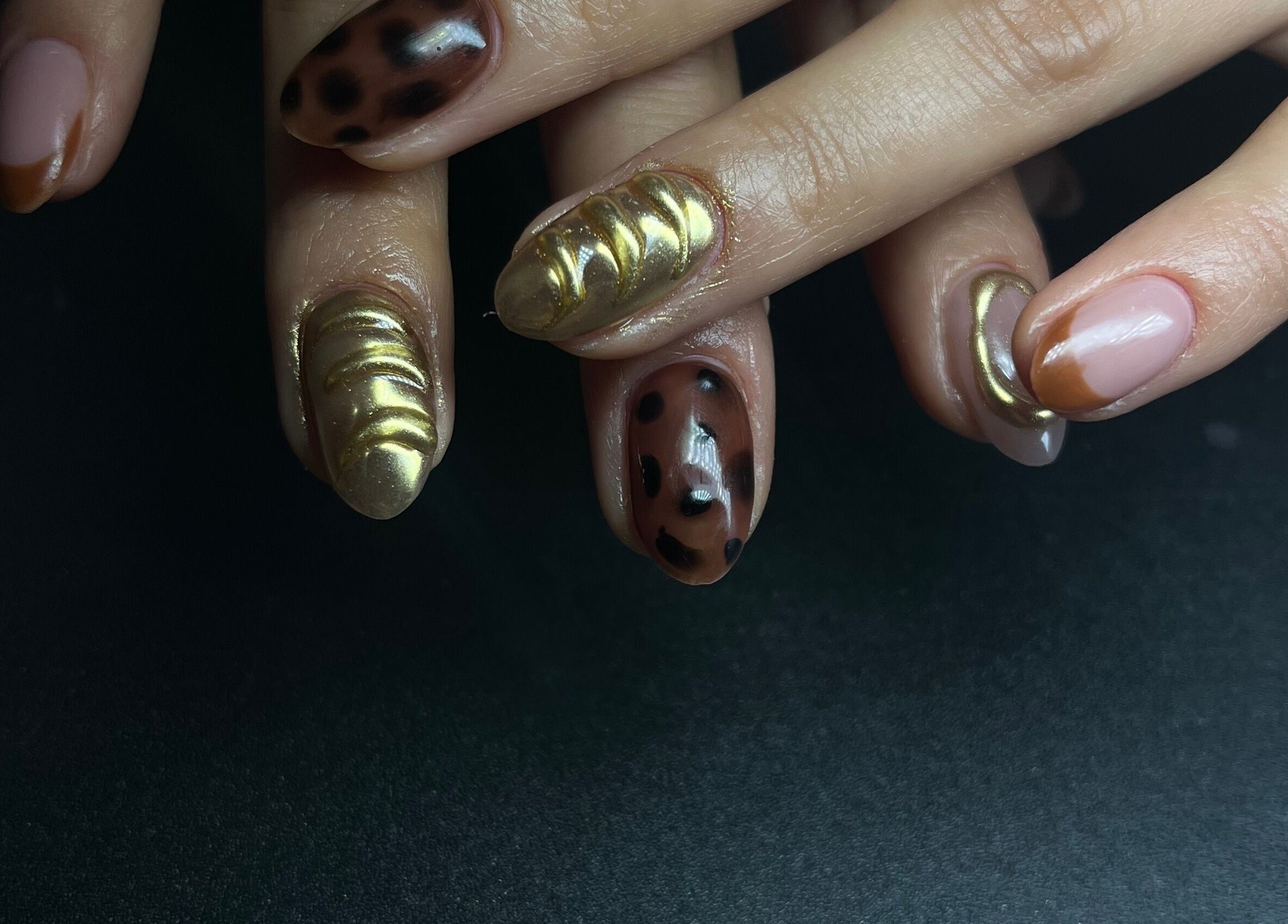 Manicura artística en Cavi Nails, Chihuahua, Chihuahua, MX. Uñas con diseño dorado y moteado.