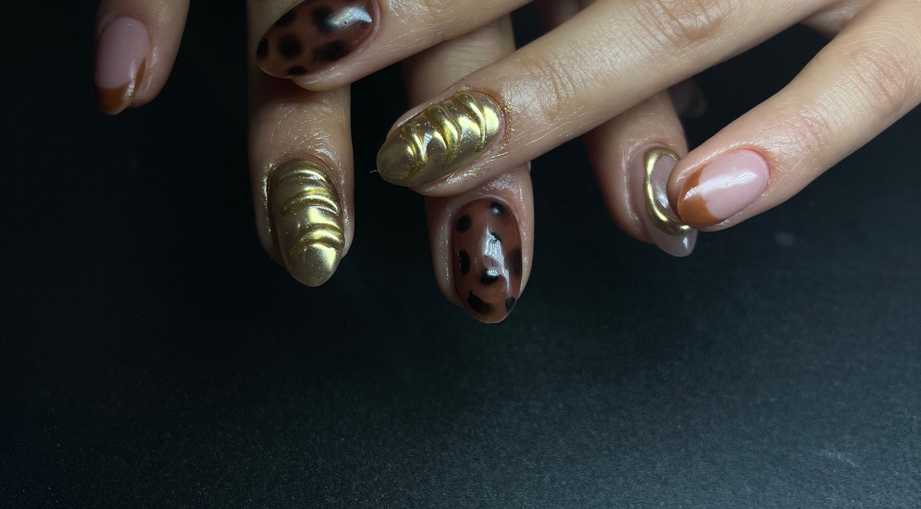 Manicura artística en Cavi Nails, Chihuahua, Chihuahua, MX. Uñas con diseño dorado y moteado.