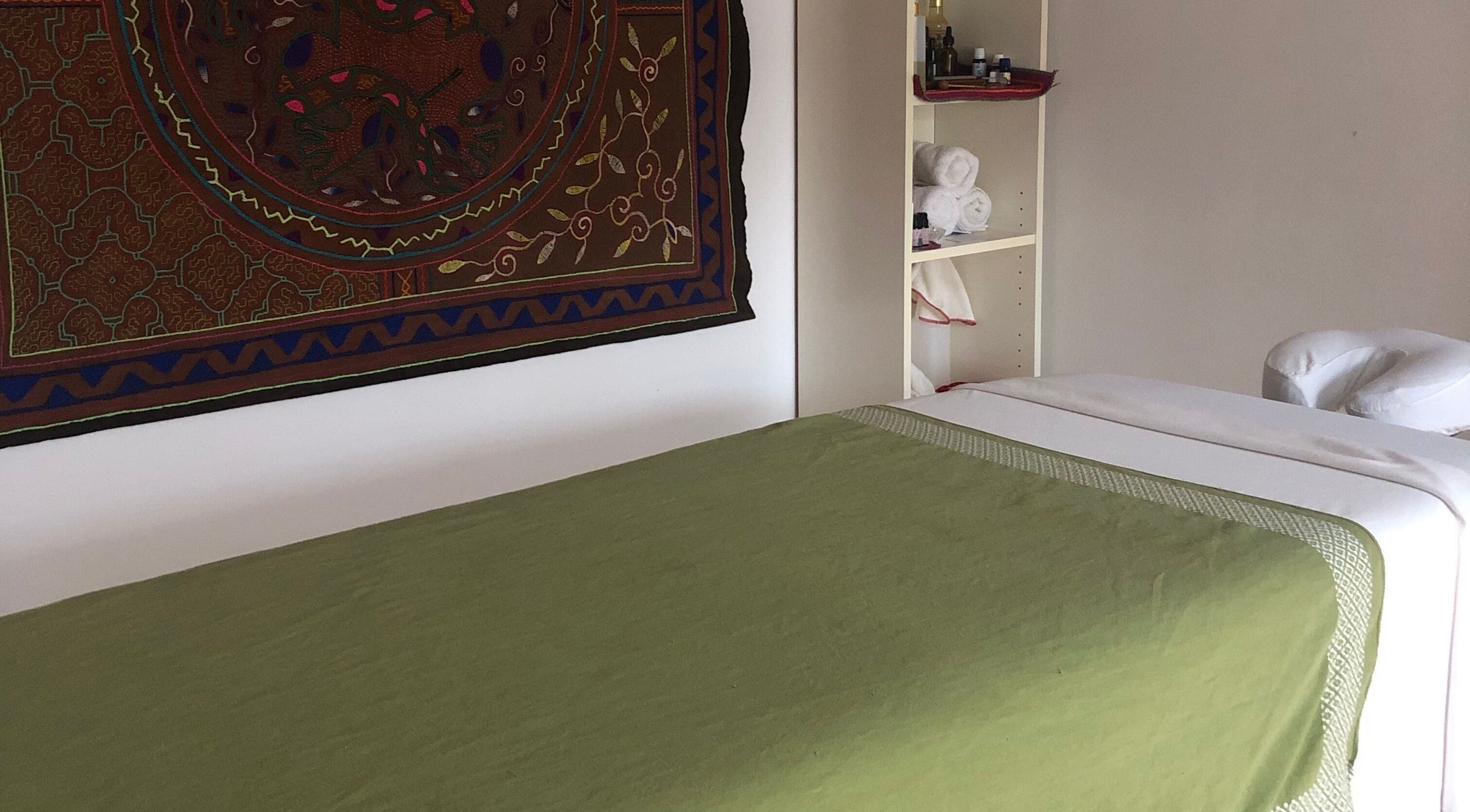 Salle de massage de Amparo ૐ massage & reiki & bioenergetics à Montréal, Québec, CA avec lit vert et décoration murale.