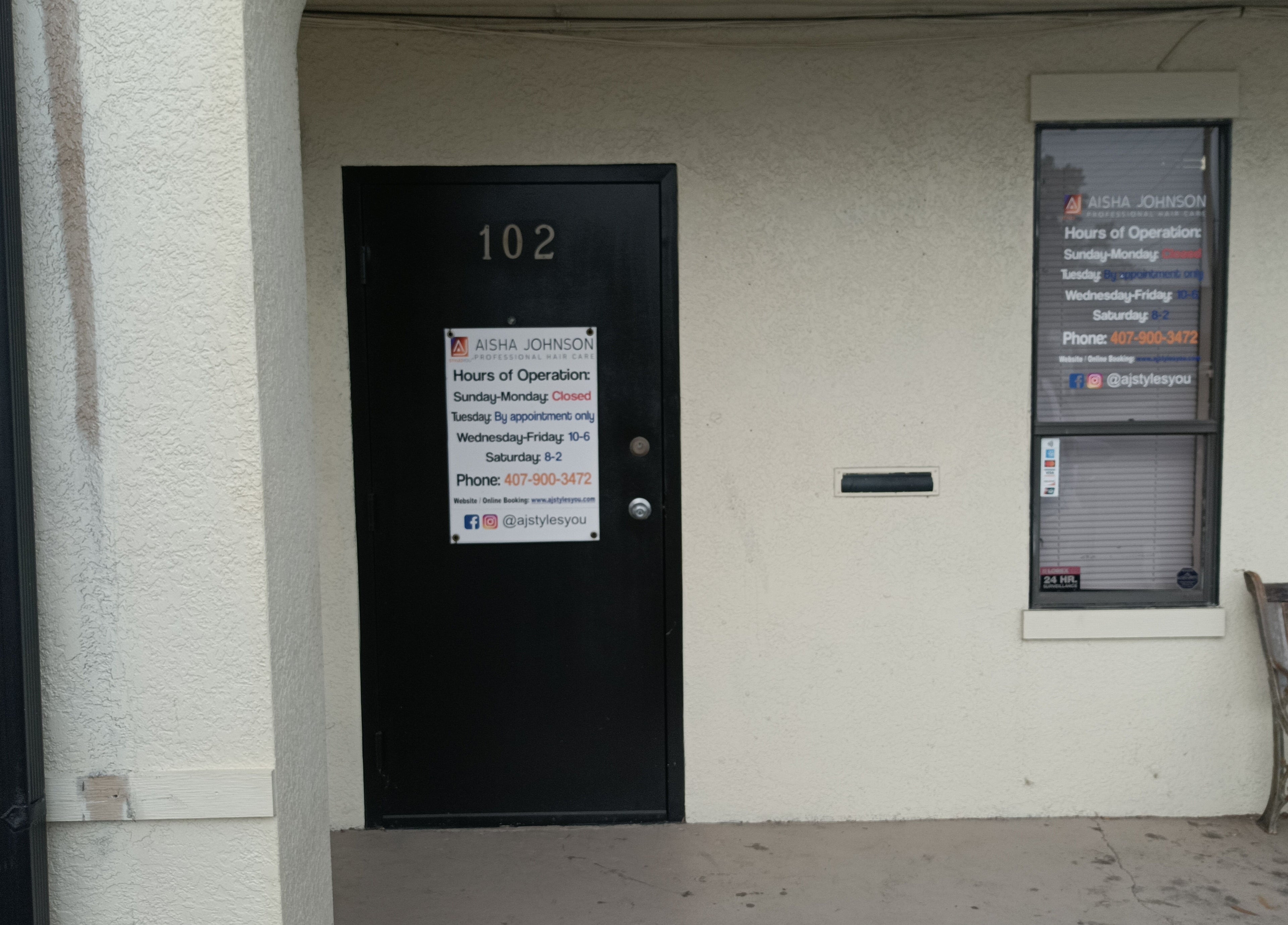 Front entrance of AJ Styles You Salon in Orlando, Florida, US, showcasing hours and contact details on the door.