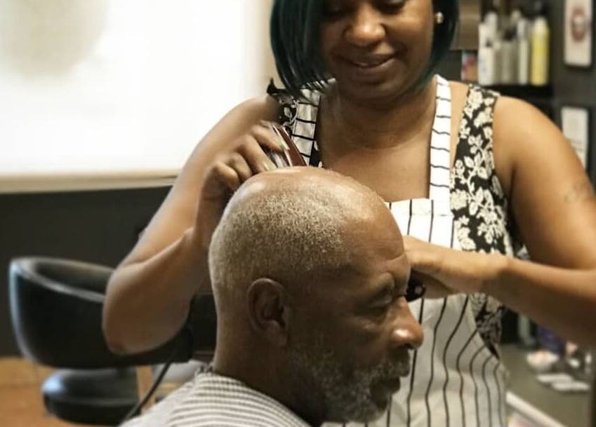 An experienced stylist cutting hair at AJ Styles You Salon in Orlando, Florida, US.