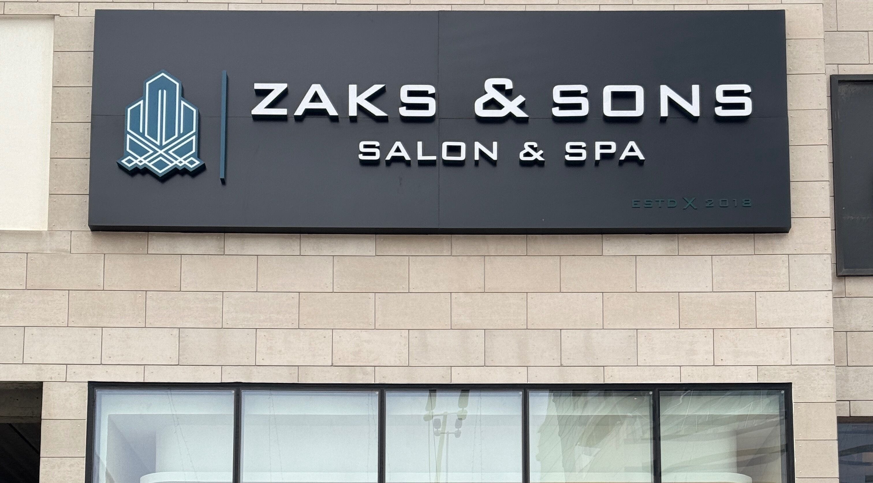 Signage of Zaks and Sons Salon and Spa in Manama, Capital Governorate, BH on a stylish stone facade.