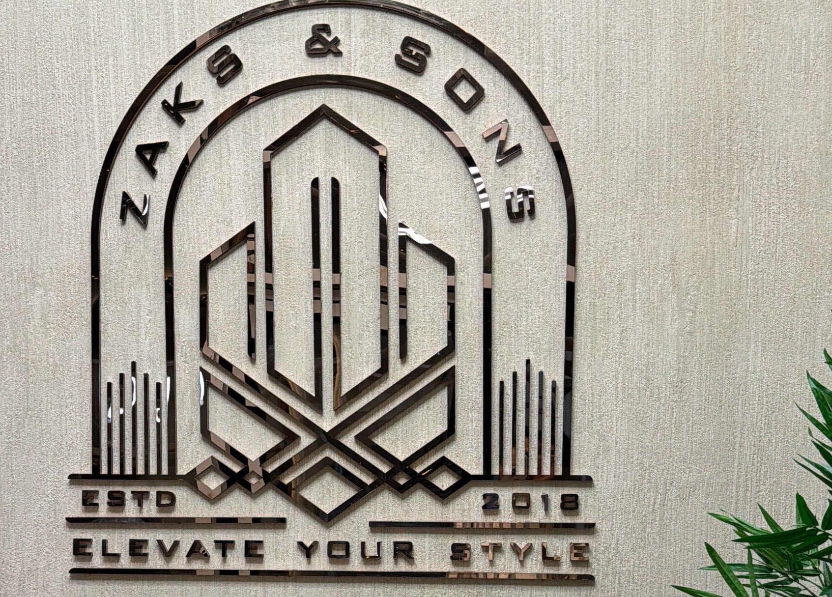 Zaks and Sons Salon and Spa logo on textured wall, Manama, Capital Governorate, BH.
