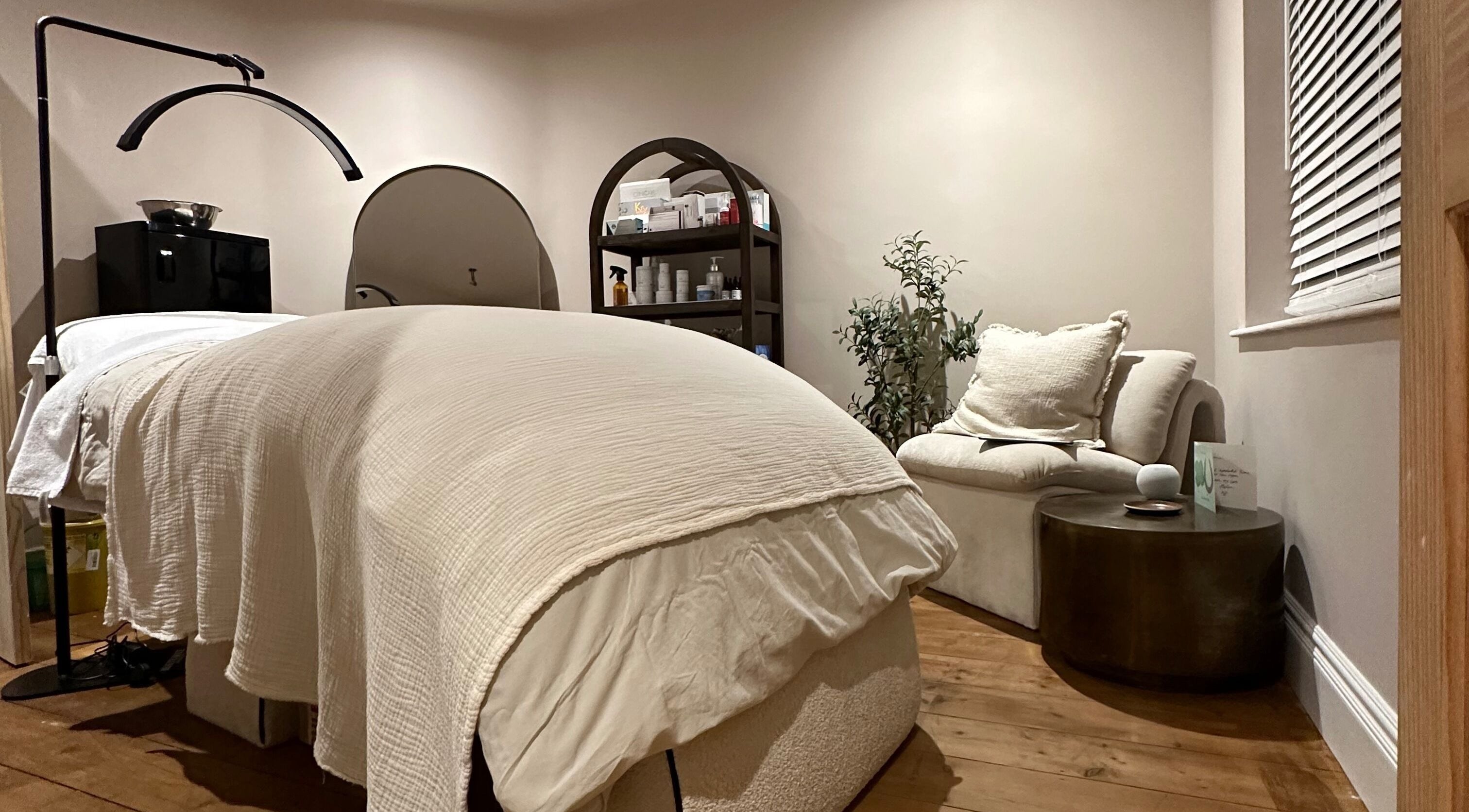 Calming treatment room at Victoria Mancini Skin, Wellington, England, GB with soothing decor and a cozy bed.