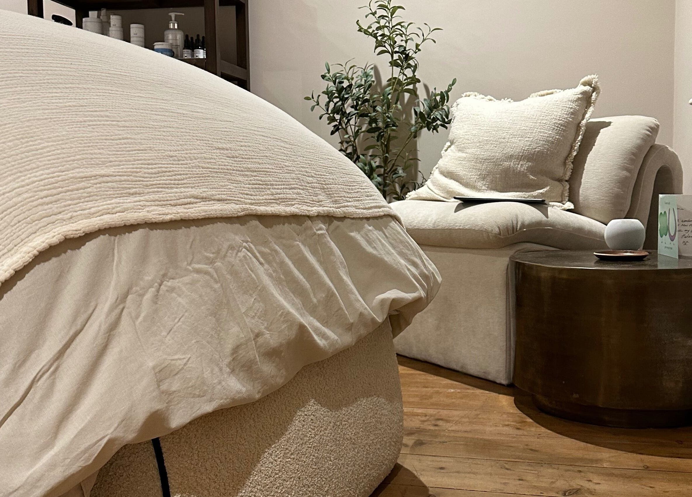 Calm, cozy interior at Victoria Mancini Skin, Wellington, England, GB with a plush chair and wooden accents.