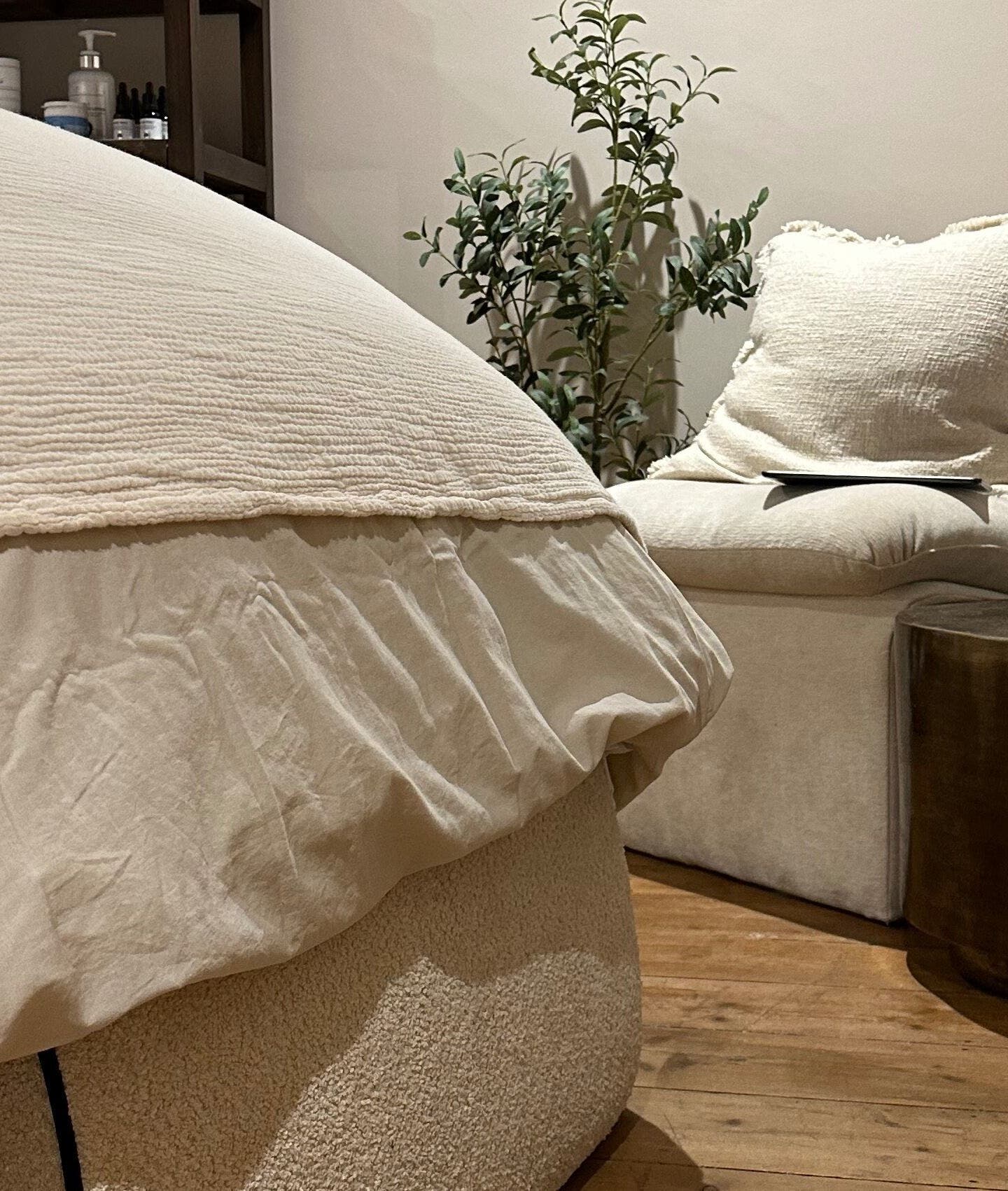 Calm, cozy interior at Victoria Mancini Skin, Wellington, England, GB with a plush chair and wooden accents.