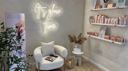 Elegant lounge at The Glow Skin Clinic in Caddington, Luton, England, GB with neon sign and skincare display.