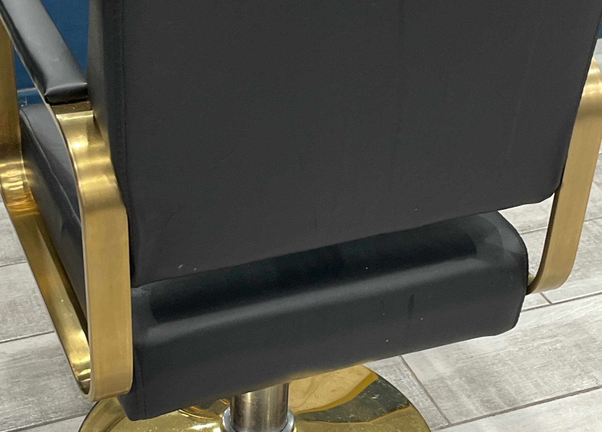 Luxury salon chair at Milees Beauty Studio, Pretoria, Gauteng, ZA, with sleek black upholstery and golden accents.