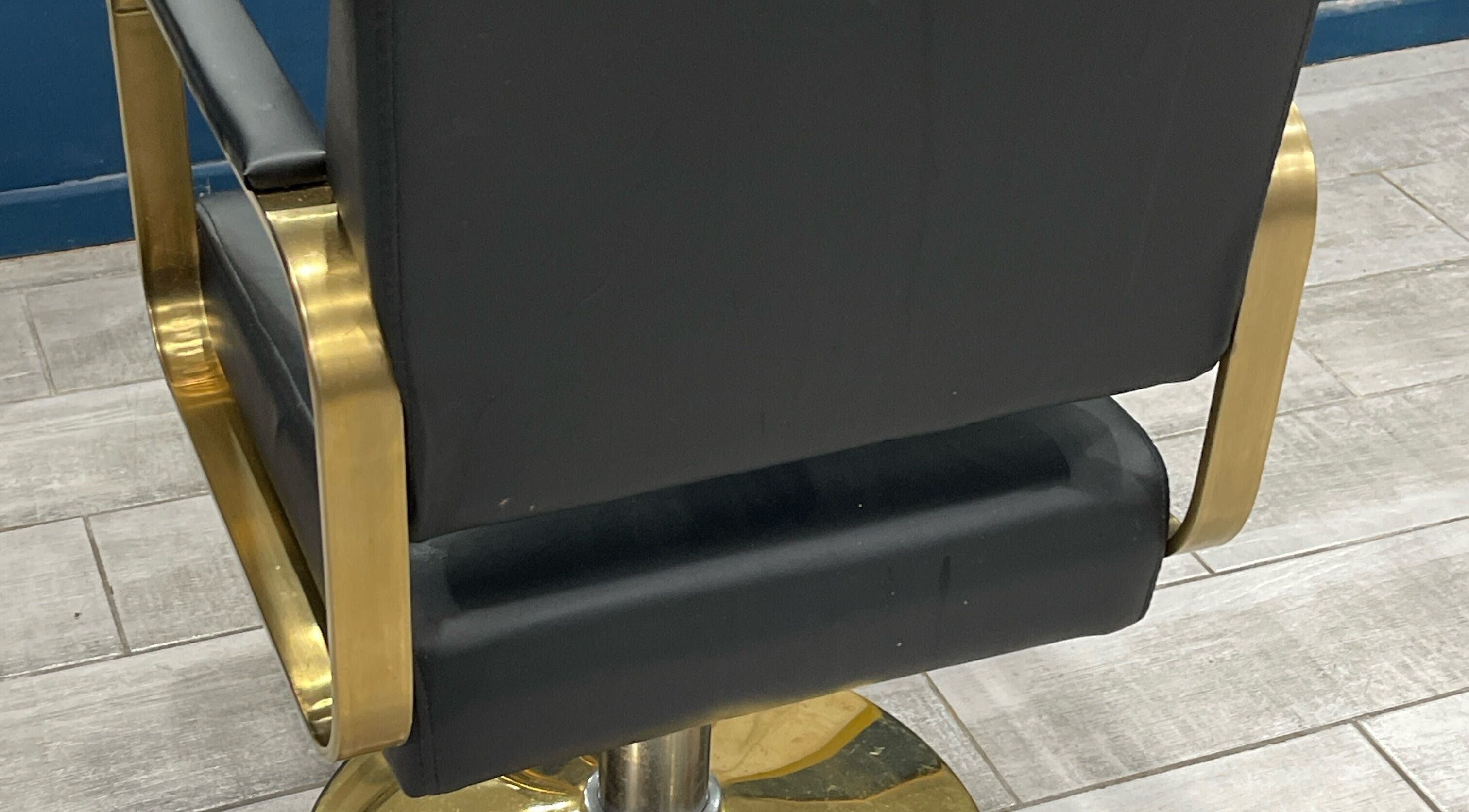 Luxury salon chair at Milees Beauty Studio, Pretoria, Gauteng, ZA, with sleek black upholstery and golden accents.