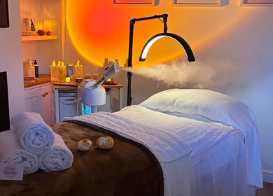 Luxurious spa room at Home Therapy in Kidderminster, England, GB with warm lighting and neatly rolled towels.