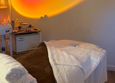 Cozy massage room at Home Therapy, Kidderminster, England, GB with warm lighting and elegant decor.