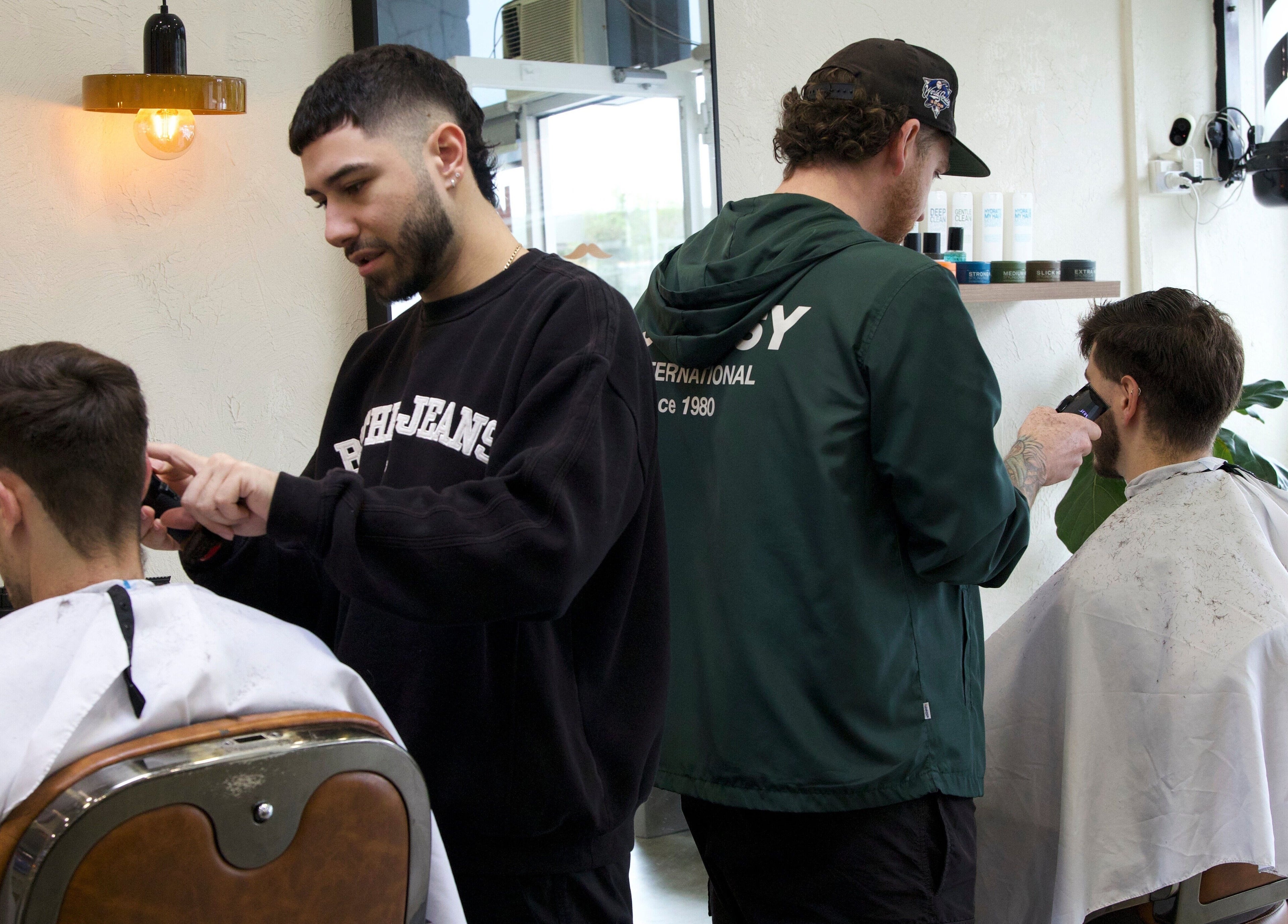 Barbers at Blck and Brwn Barber Shop in Melbourne, Victoria, AU delivering stylish haircuts to clients.