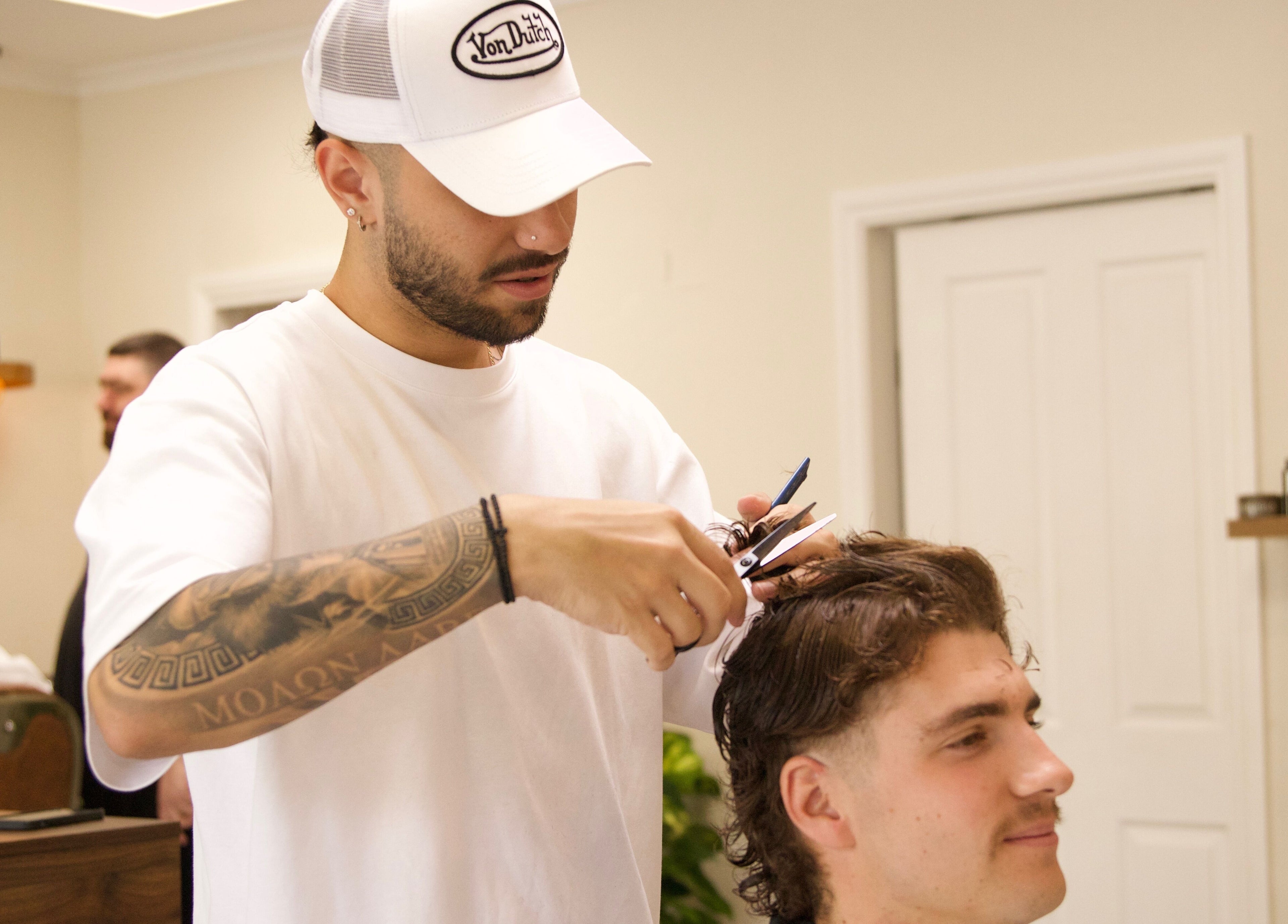 Hairdresser at Blck and Brwn Barber Shop, Melbourne, Victoria, AU, styling client with precision.