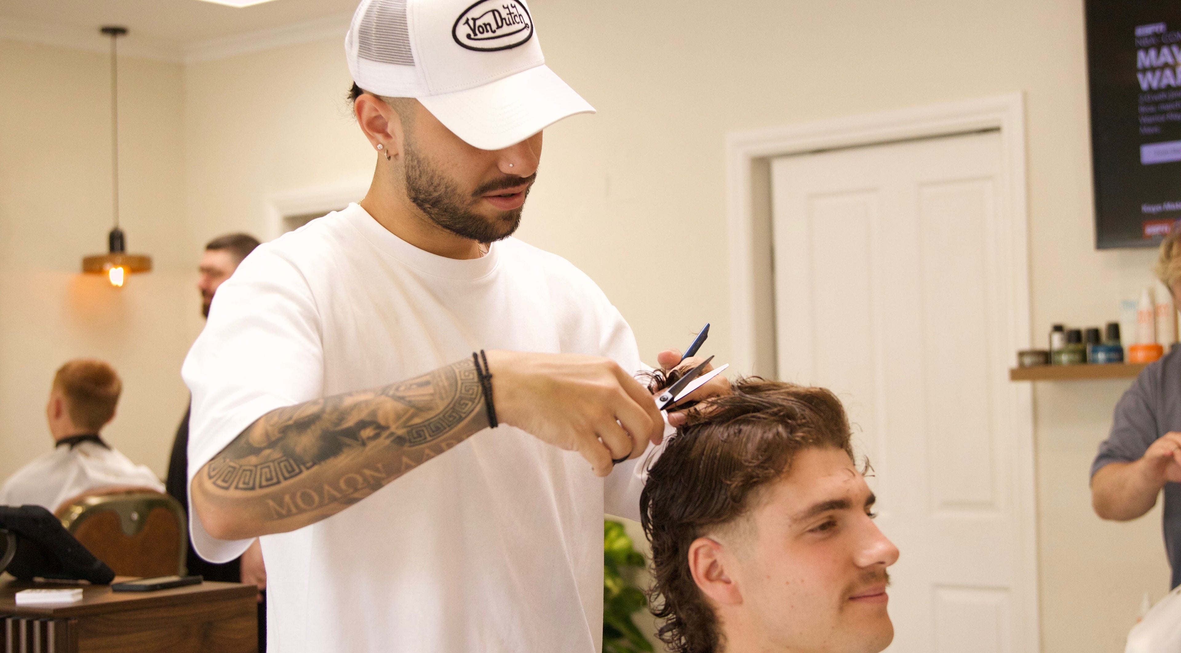 Hairdresser at Blck and Brwn Barber Shop, Melbourne, Victoria, AU, styling client with precision.