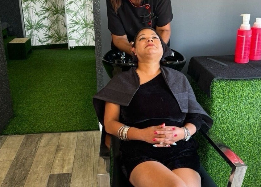 Relaxing hair wash at La Bella's Hair and Beauty Salon, Cape Town, Western Cape, ZA with lush green decor.